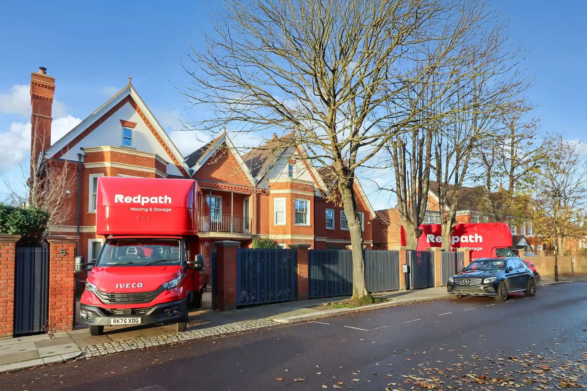 Family carrying labelled boxes into a warm home on a winter day