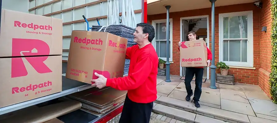 Students unpacking boxes in a shared London apartment