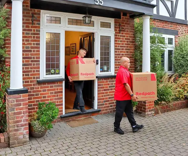 Redpath crew carefully loading a storage container in a North London home